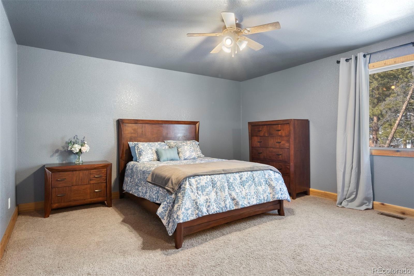 412 Evergreen Road Black Hawk, CO 80422 - Photo 37 of 48 a bedroom with a bed and a chandelier