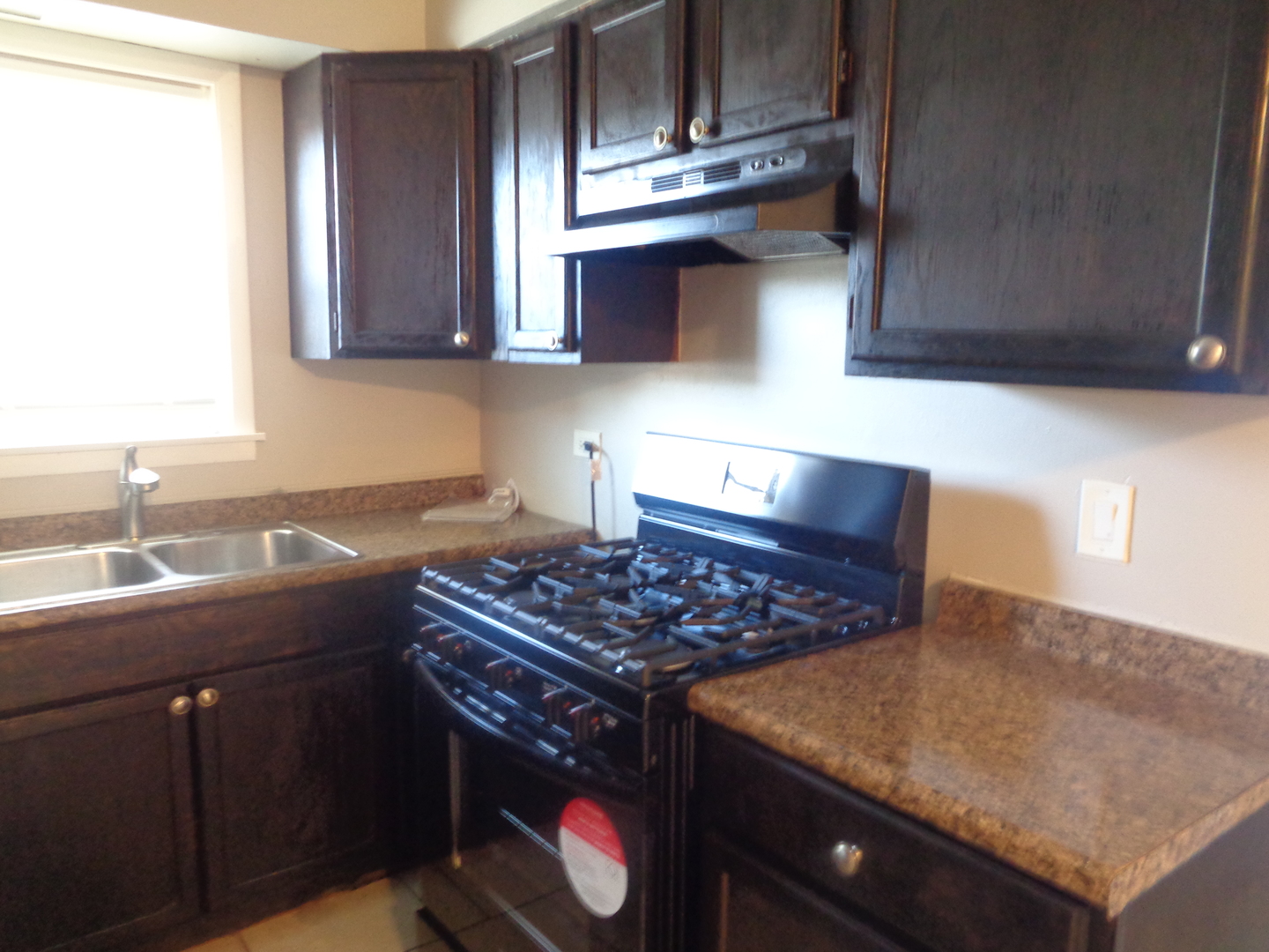 8149 83rd Place, Unit 2 Justice, IL 60458 - Photo 7 of 10 a kitchen with stainless steel appliances granite countertop a sink a stove and a microwave