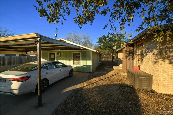 a view of a chair and table in the back yard of the house