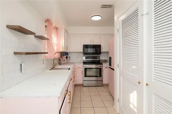 a kitchen with a sink a microwave and cabinets