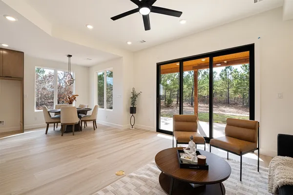a living room with furniture kitchen view and a chandelier