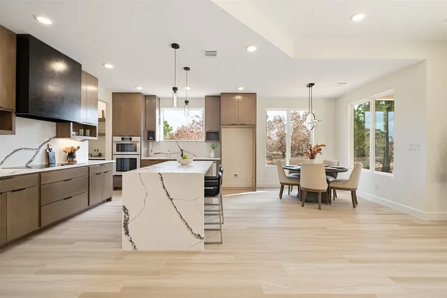 a dining room with furniture a chandelier and wooden floor