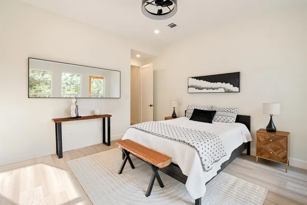 a bedroom with a bed and a flat tv screen on dresser