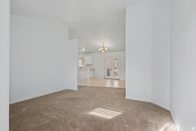 281 Winchester Drive Springville, UT 84663 - Photo 15 of 27 Unfurnished room featuring light colored carpet, a chandelier, french doors, and vaulted ceiling