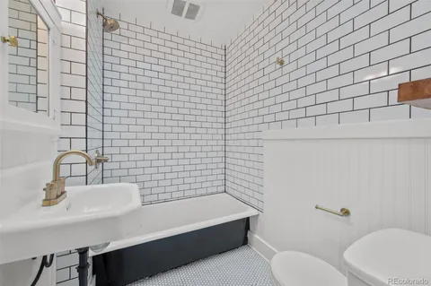 a bathroom with a sink a toilet and mirror