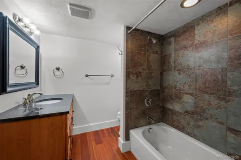 a bathroom with a granite countertop sink toilet and shower