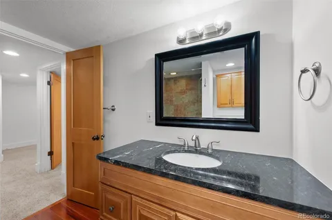 a bathroom with a granite countertop sink and a mirror