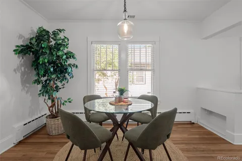 a dining room with furniture potted plants and wooden floor