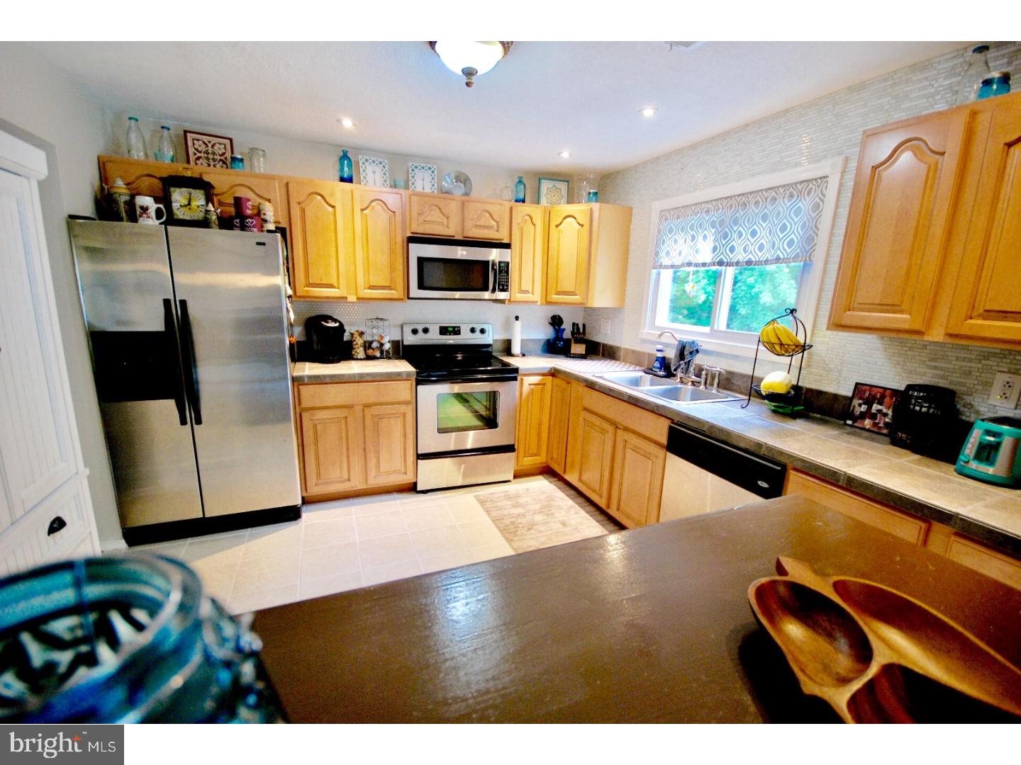 23 Orion Way Sewell, NJ 08080 - Photo 11 of 25 a kitchen with stainless steel appliances granite countertop a sink dishwasher stove top oven and cabinets with wooden floor