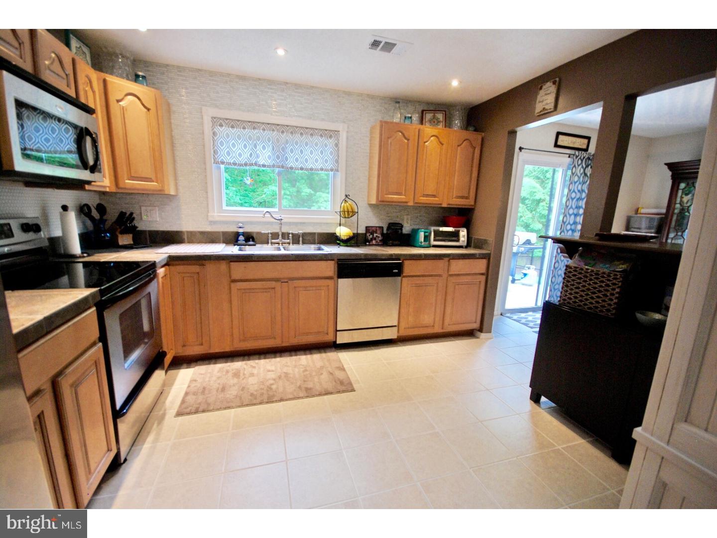 23 Orion Way Sewell, NJ 08080 - Photo 12 of 25 a kitchen with stainless steel appliances granite countertop a stove a sink dishwasher and a microwave