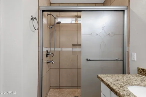 a bathroom with a granite countertop shower and a sink