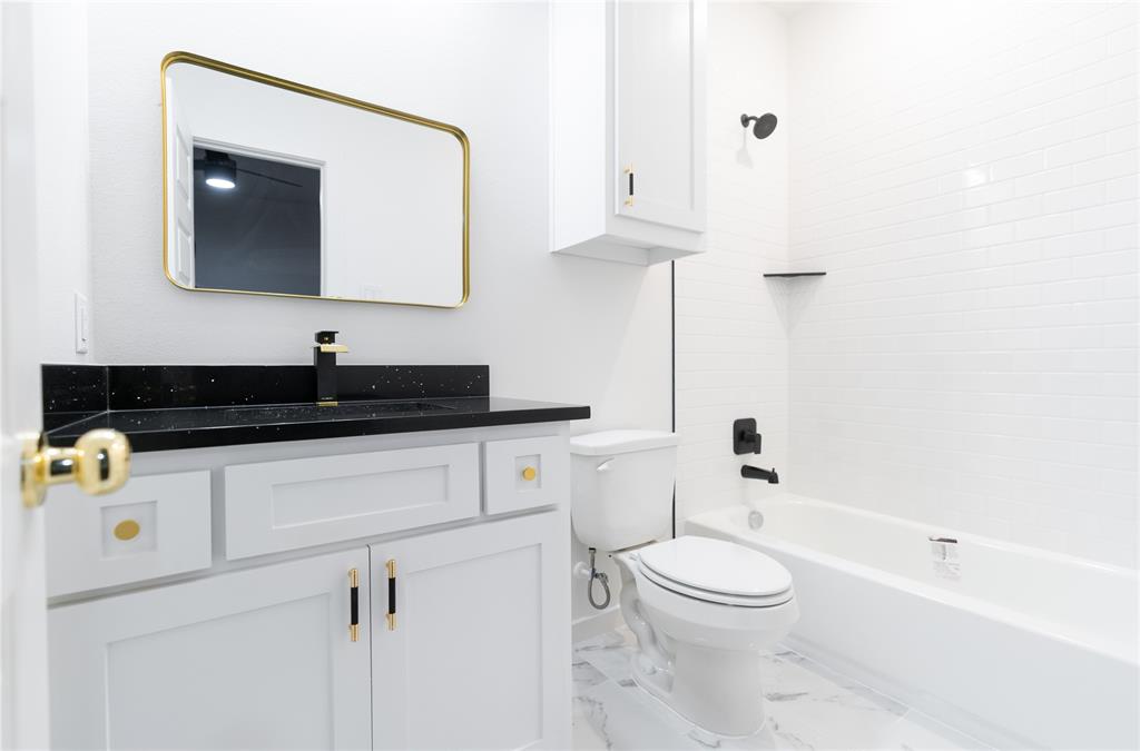 839 Southwest 7th Street Cooper, TX 75432 - Photo 17 of 21 Bathroom featuring marble finish floor, toilet, shower / tub combination, vanity, and baseboards