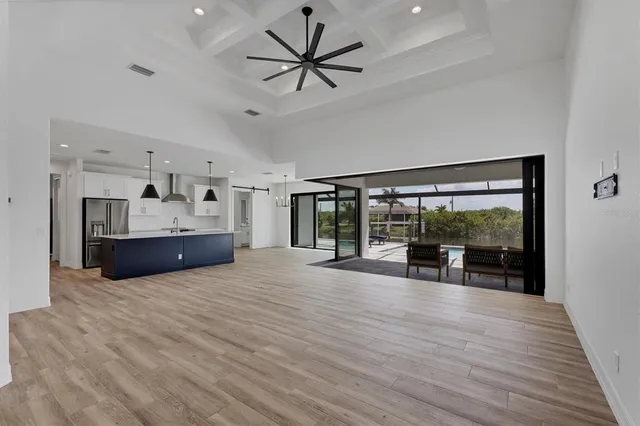 a kitchen with stainless steel appliances granite countertop a sink a stove a refrigerator and island with wooden floor