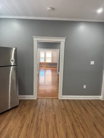 an empty room with wooden floor and entrance