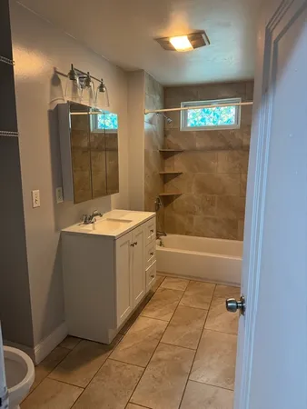 a bathroom with a sink a toilet and shower