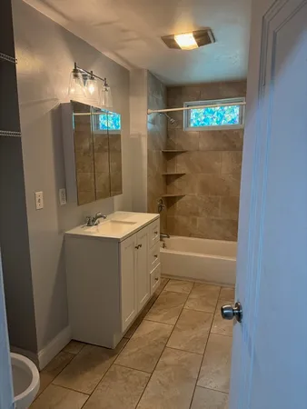 a bathroom with a tub sink and mirror
