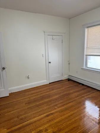 a view of a room with wooden floor and window