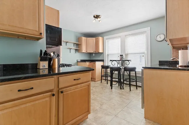 a kitchen with appliances cabinets and chair