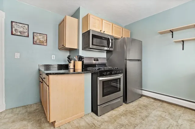 a kitchen with stainless steel appliances granite countertop a stove a refrigerator and a microwave