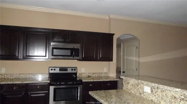 a kitchen with stainless steel appliances granite countertop a stove and a microwave