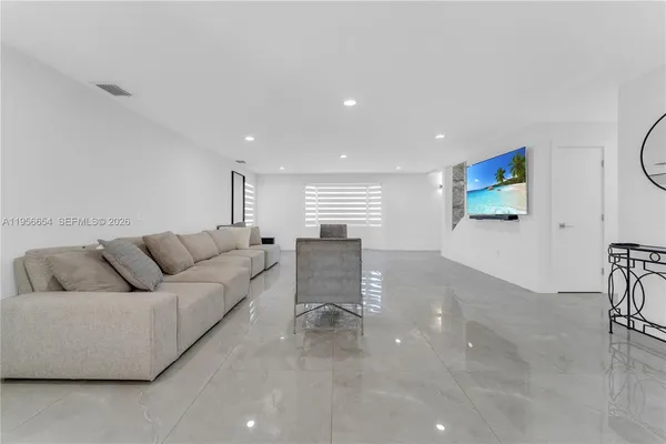 a kitchen with stainless steel appliances a stove a sink a counter top space cabinets and a window