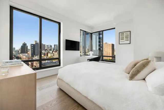 a bedroom with a large bed and a flat screen tv