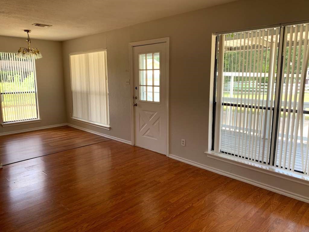 62 Laurel Court Cleveland, TX 77327 - Photo 4 of 28 a view of an empty room with wooden floor and a window