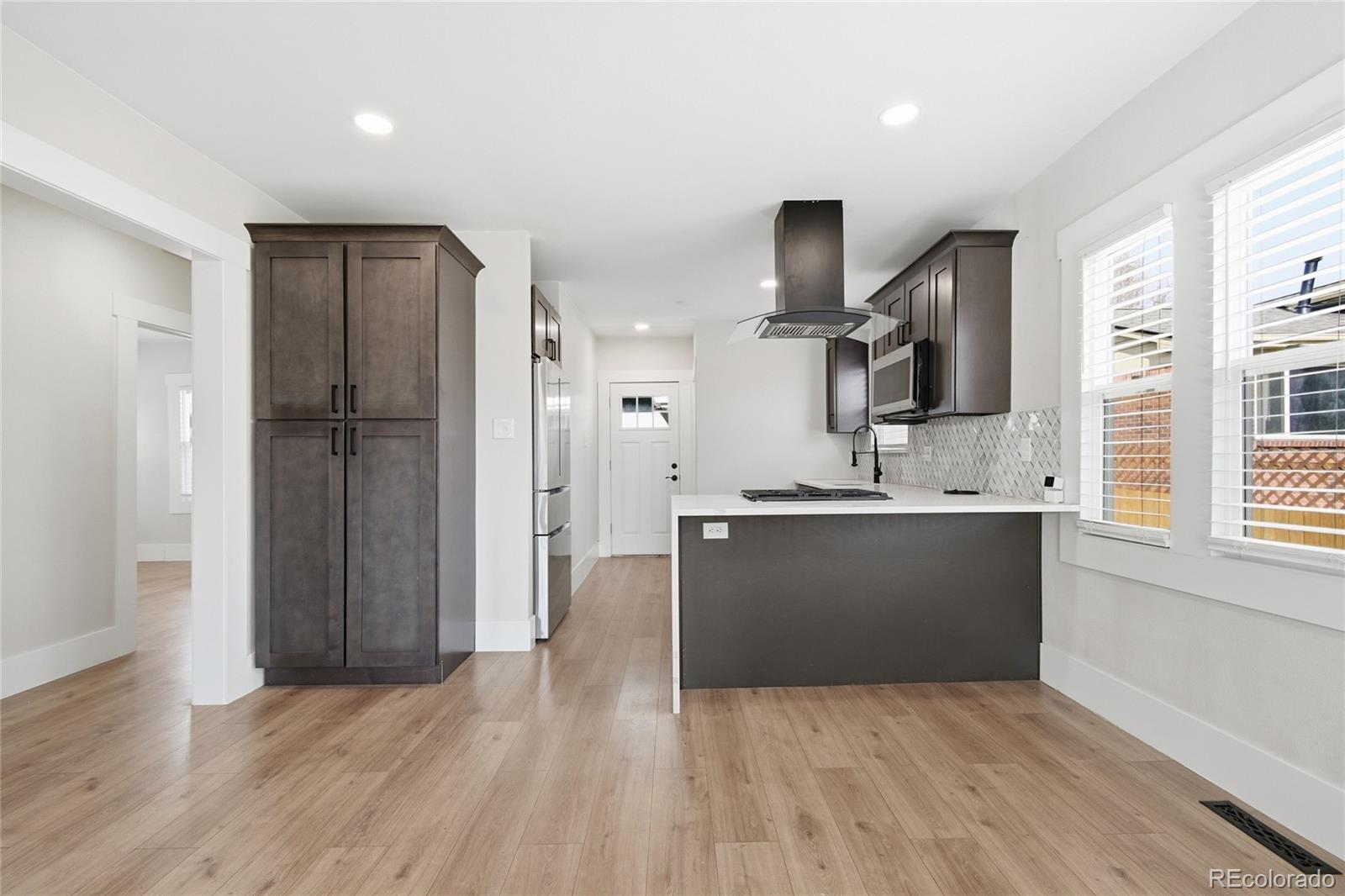 3417 West Alaska Place Denver, CO 80219 - Photo 13 of 30 a view of kitchen with stainless steel appliances kitchen island wooden floor and window