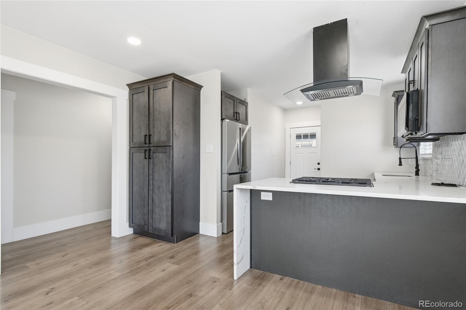 3417 West Alaska Place Denver, CO 80219 - Photo 14 of 30 a kitchen with stainless steel appliances a sink and a refrigerator