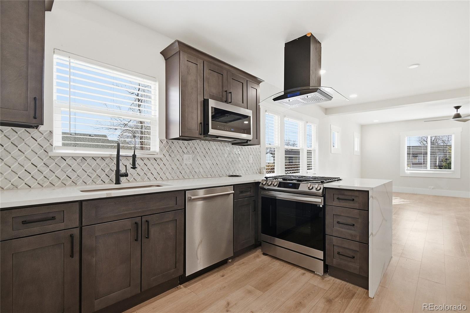 3417 West Alaska Place Denver, CO 80219 - Photo 16 of 30 a kitchen with stainless steel appliances granite countertop a sink and stove top oven