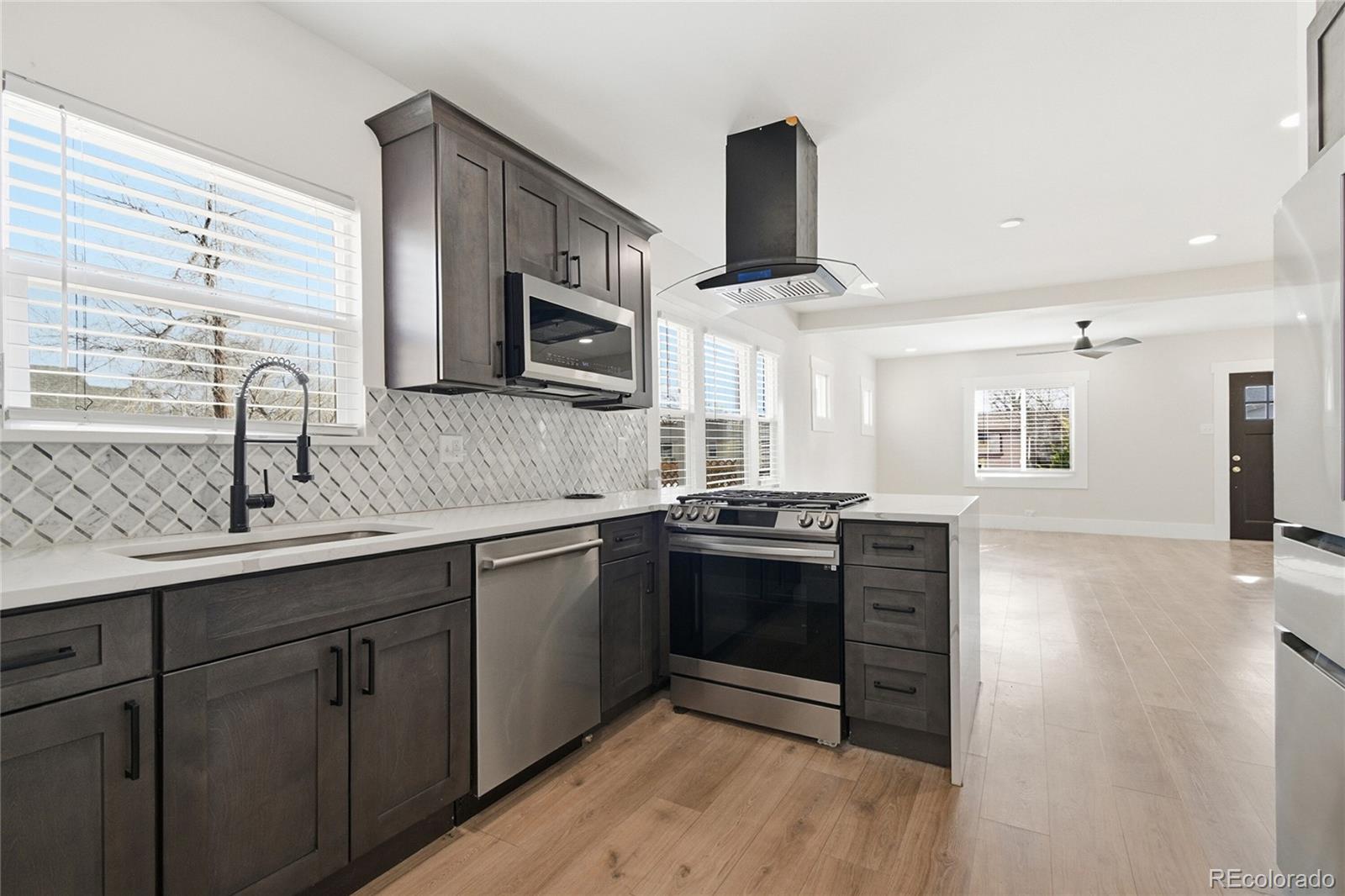 3417 West Alaska Place Denver, CO 80219 - Photo 17 of 30 a kitchen with stainless steel appliances granite countertop a sink stove and microwave