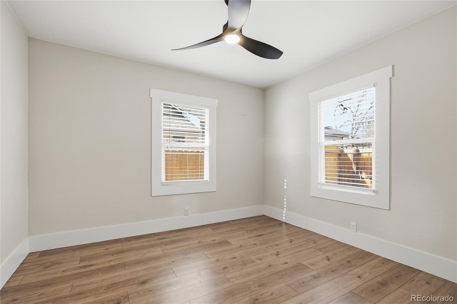 3417 West Alaska Place Denver, CO 80219 - Photo 22 of 30 a view of an empty room with wooden floor and a window