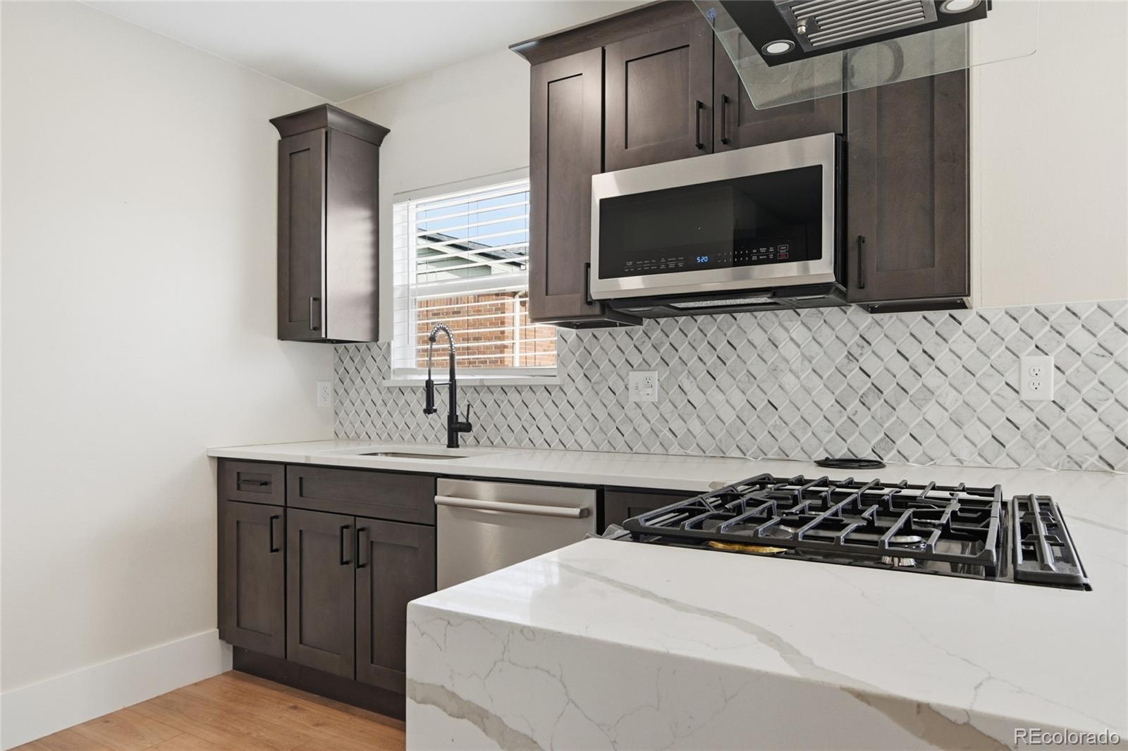 3417 West Alaska Place Denver, CO 80219 - Photo 26 of 30 a kitchen with a stove and a microwave