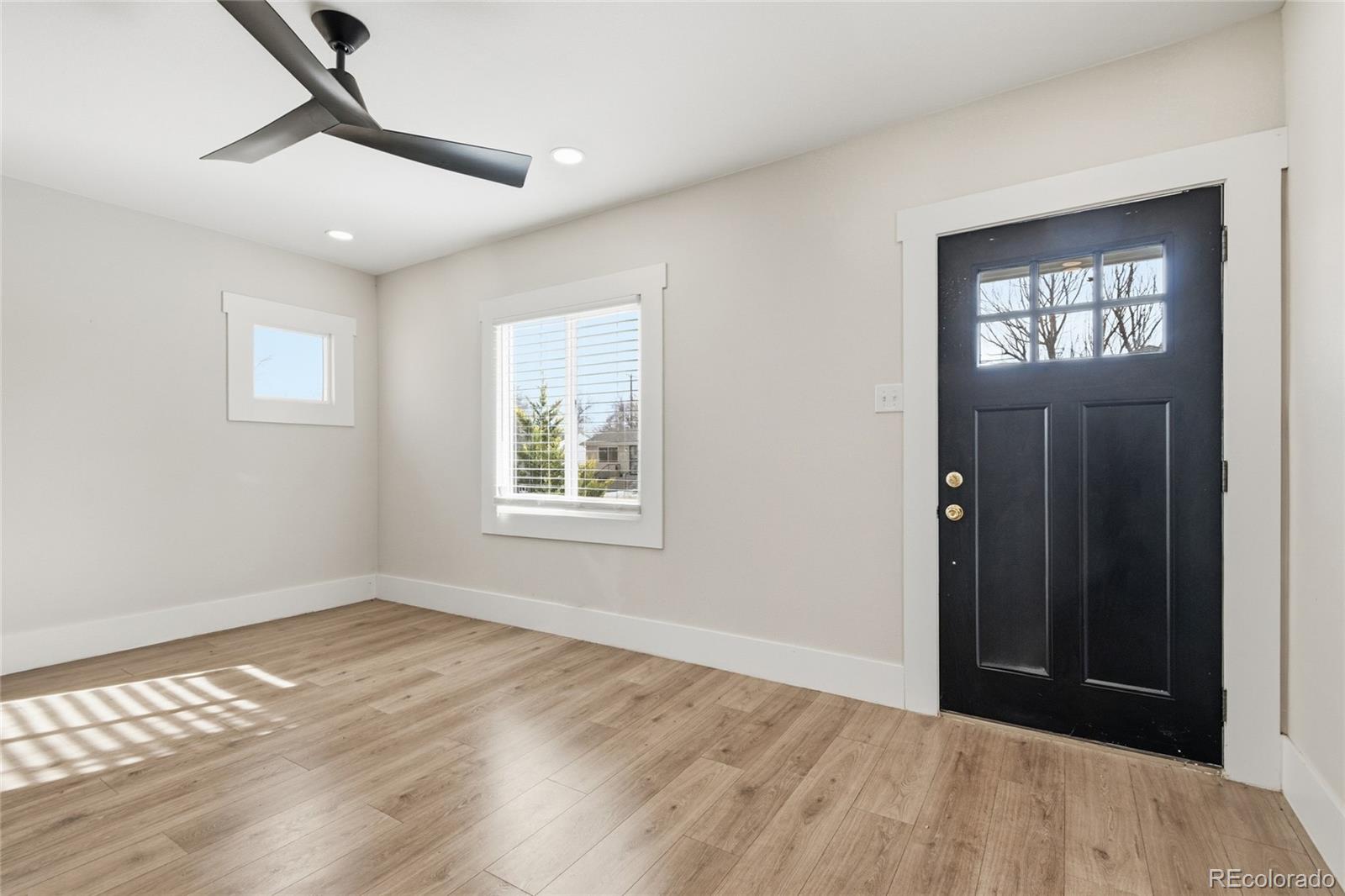 3417 West Alaska Place Denver, CO 80219 - Photo 7 of 30 a view of an empty room with wooden floor and a window