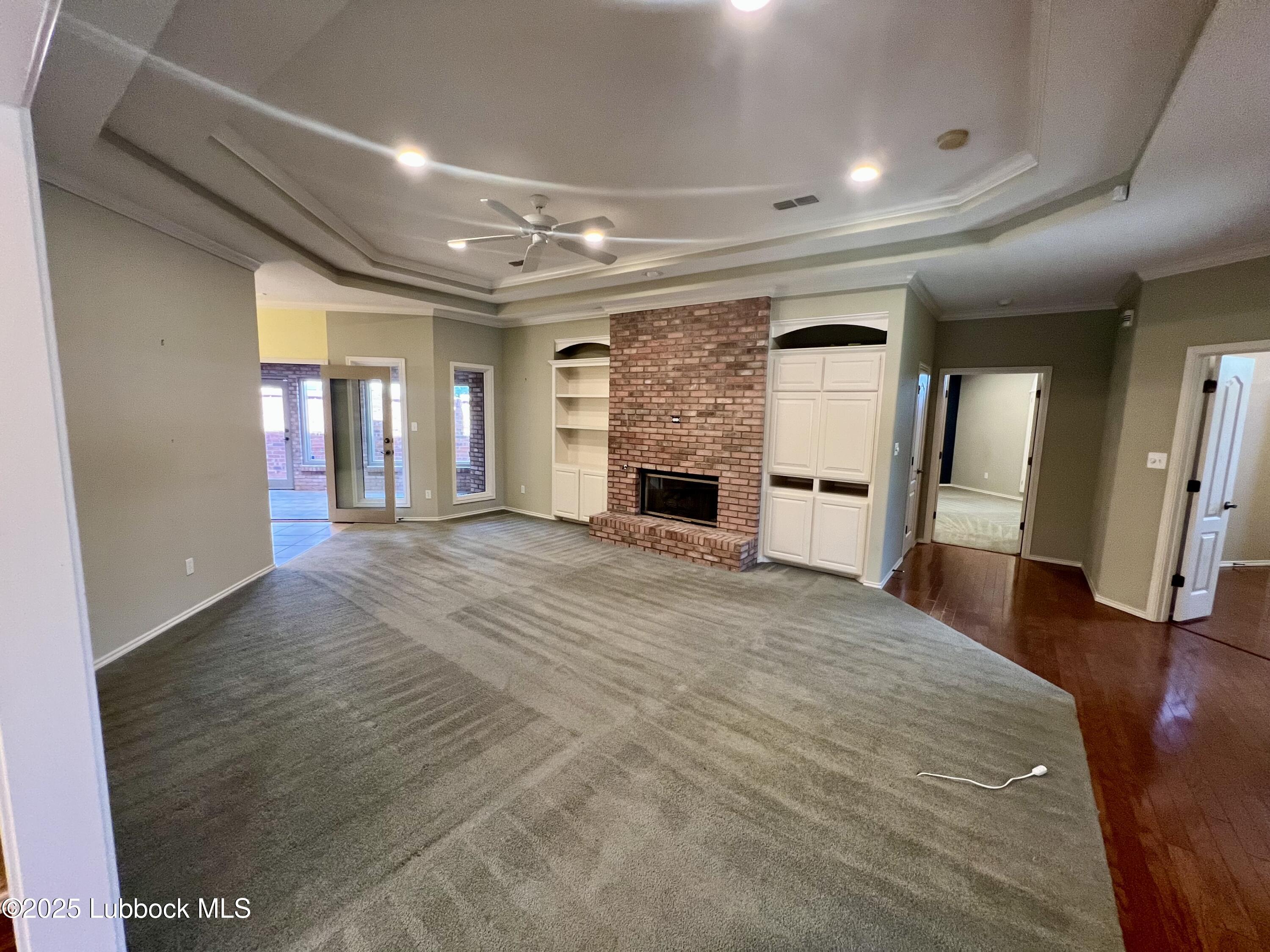 9802 Toledo Avenue Lubbock, TX 79424 - Photo 12 of 64 wooden floor in an empty room with a fireplace