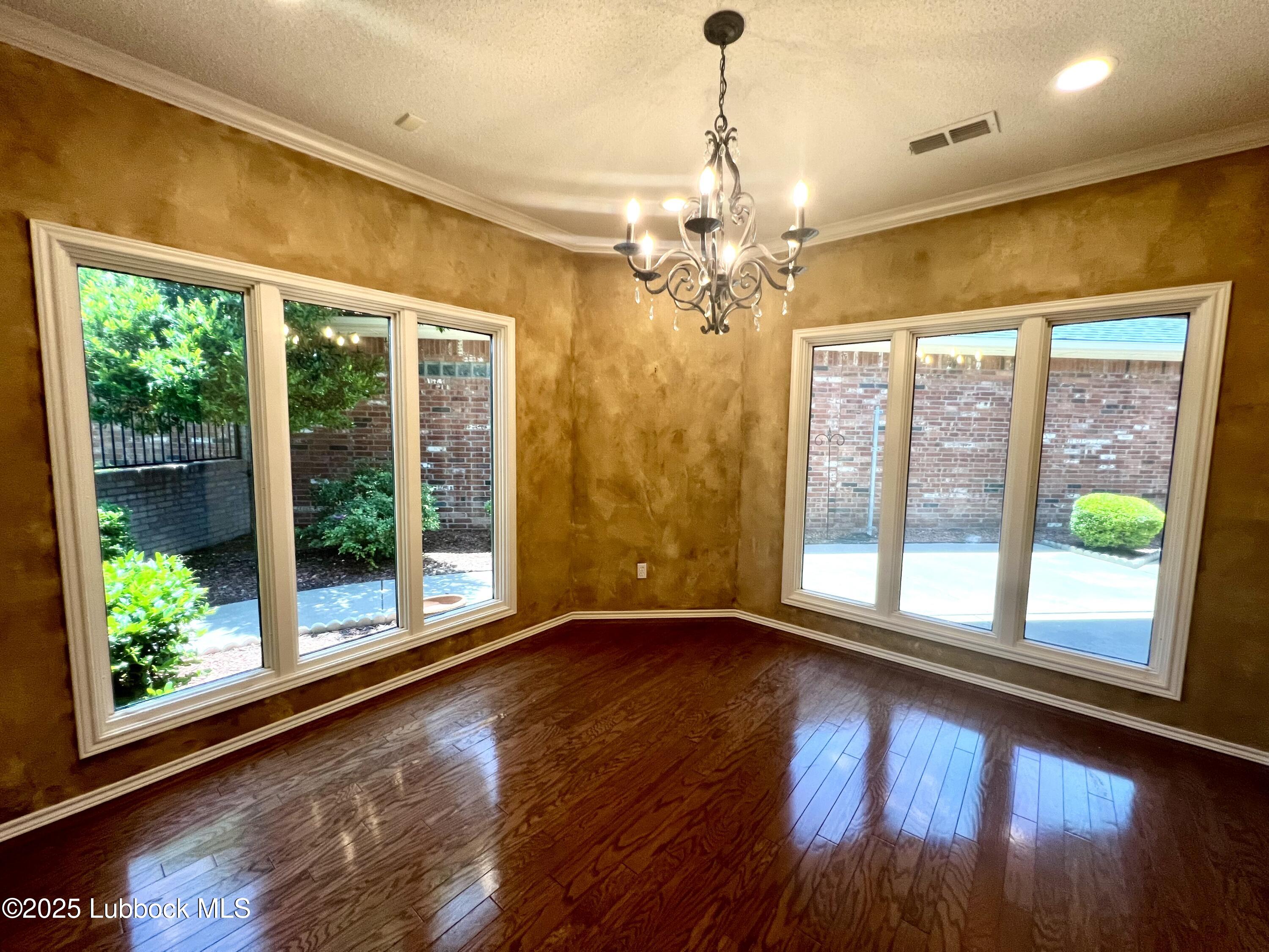 9802 Toledo Avenue Lubbock, TX 79424 - Photo 15 of 64 a view of an empty room with wooden floor and a window