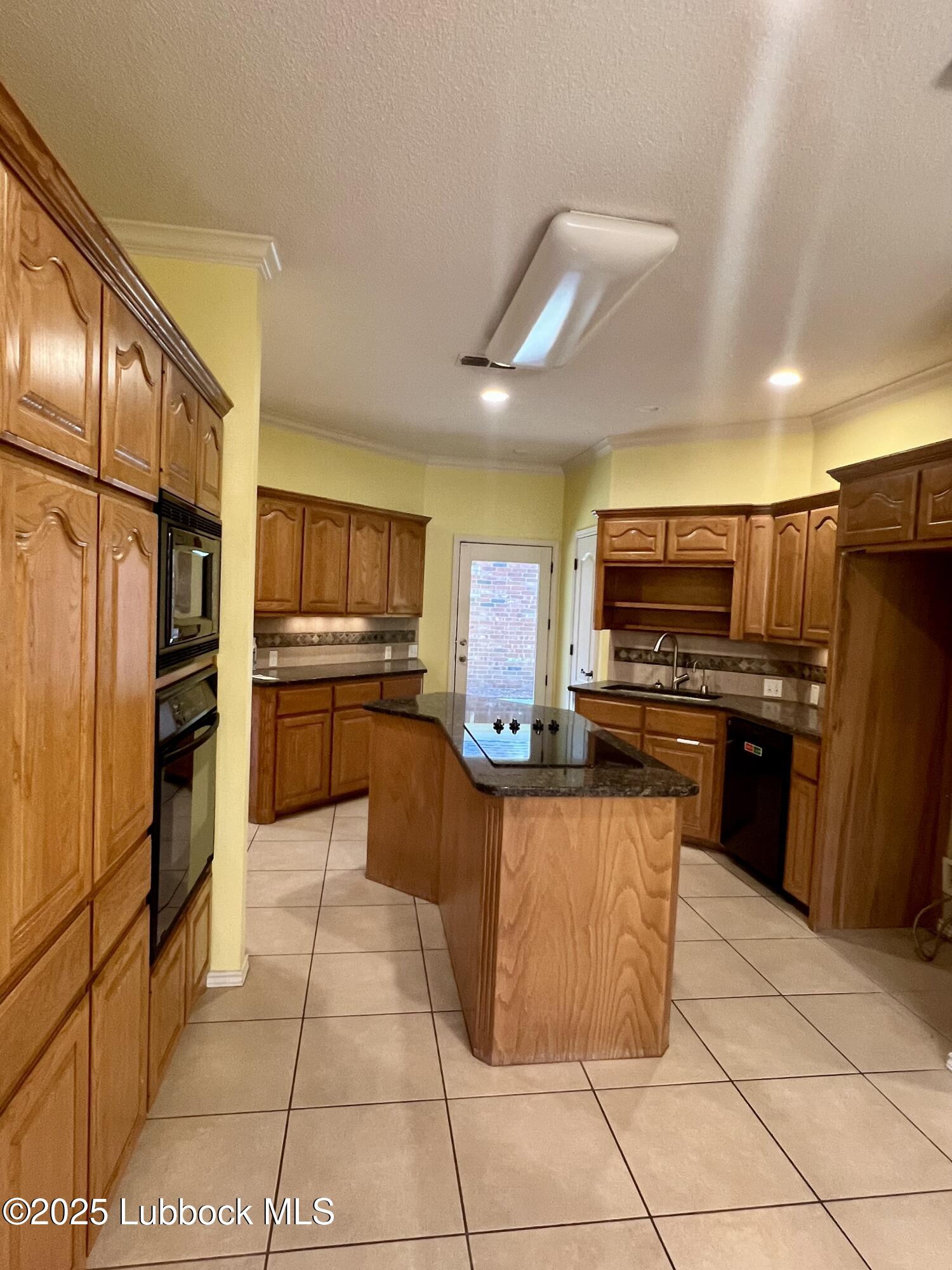 9802 Toledo Avenue Lubbock, TX 79424 - Photo 18 of 64 a kitchen with stainless steel appliances granite countertop a refrigerator and a stove top oven