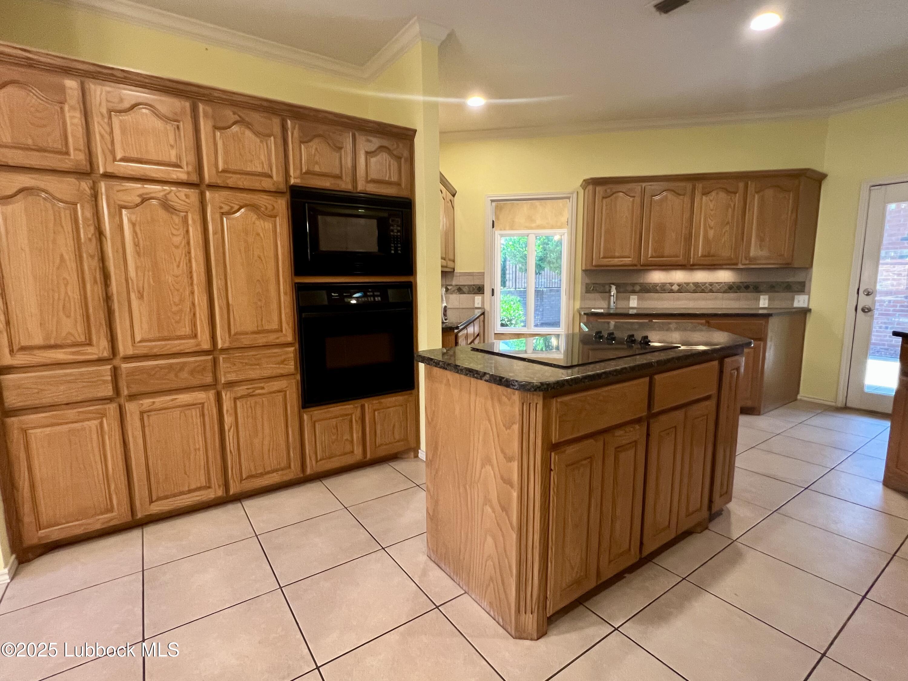 9802 Toledo Avenue Lubbock, TX 79424 - Photo 19 of 64 a kitchen with stainless steel appliances granite countertop a refrigerator and a stove