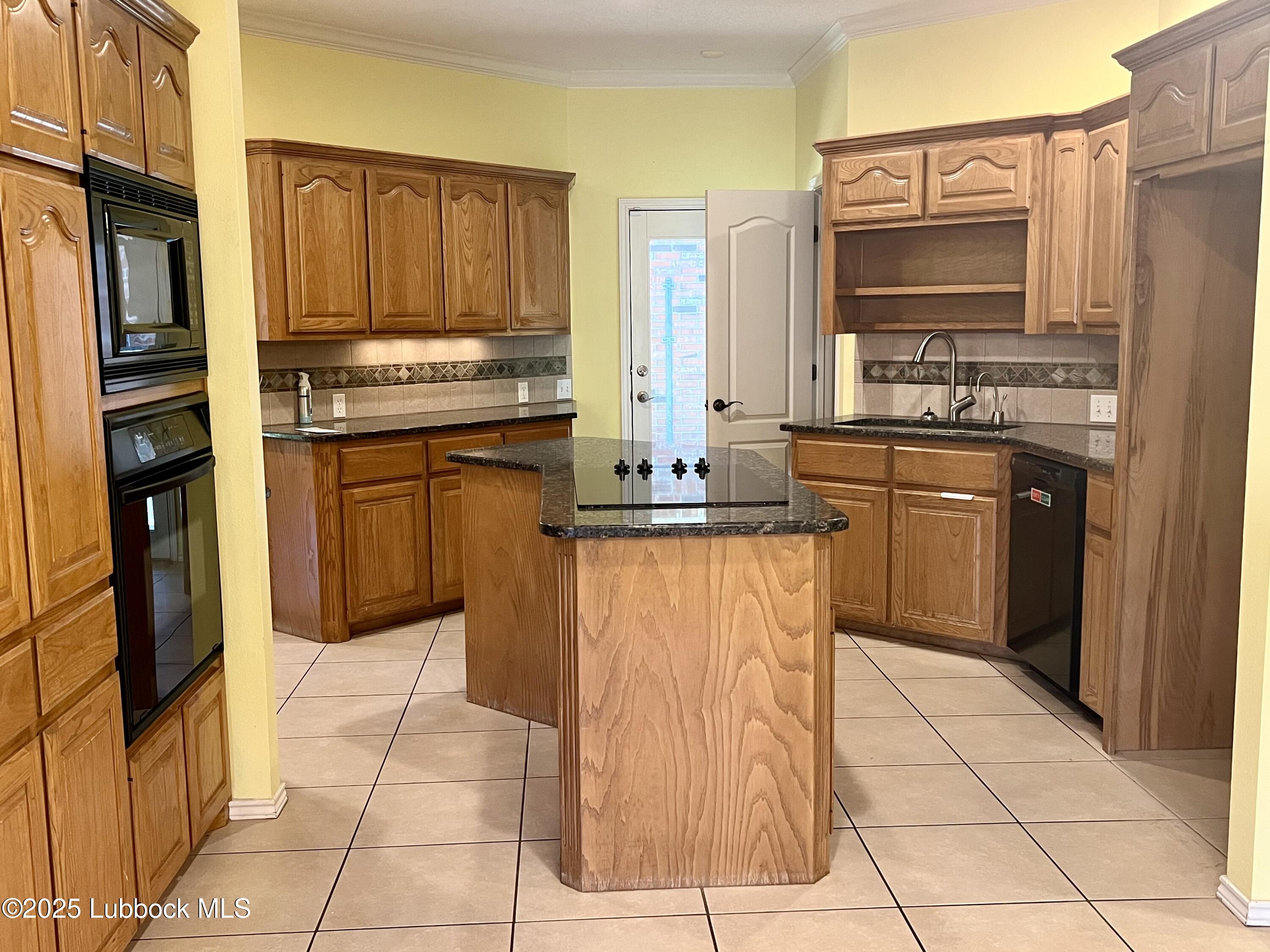 9802 Toledo Avenue Lubbock, TX 79424 - Photo 22 of 64 a kitchen with stainless steel appliances granite countertop a stove top oven microwave and cabinets