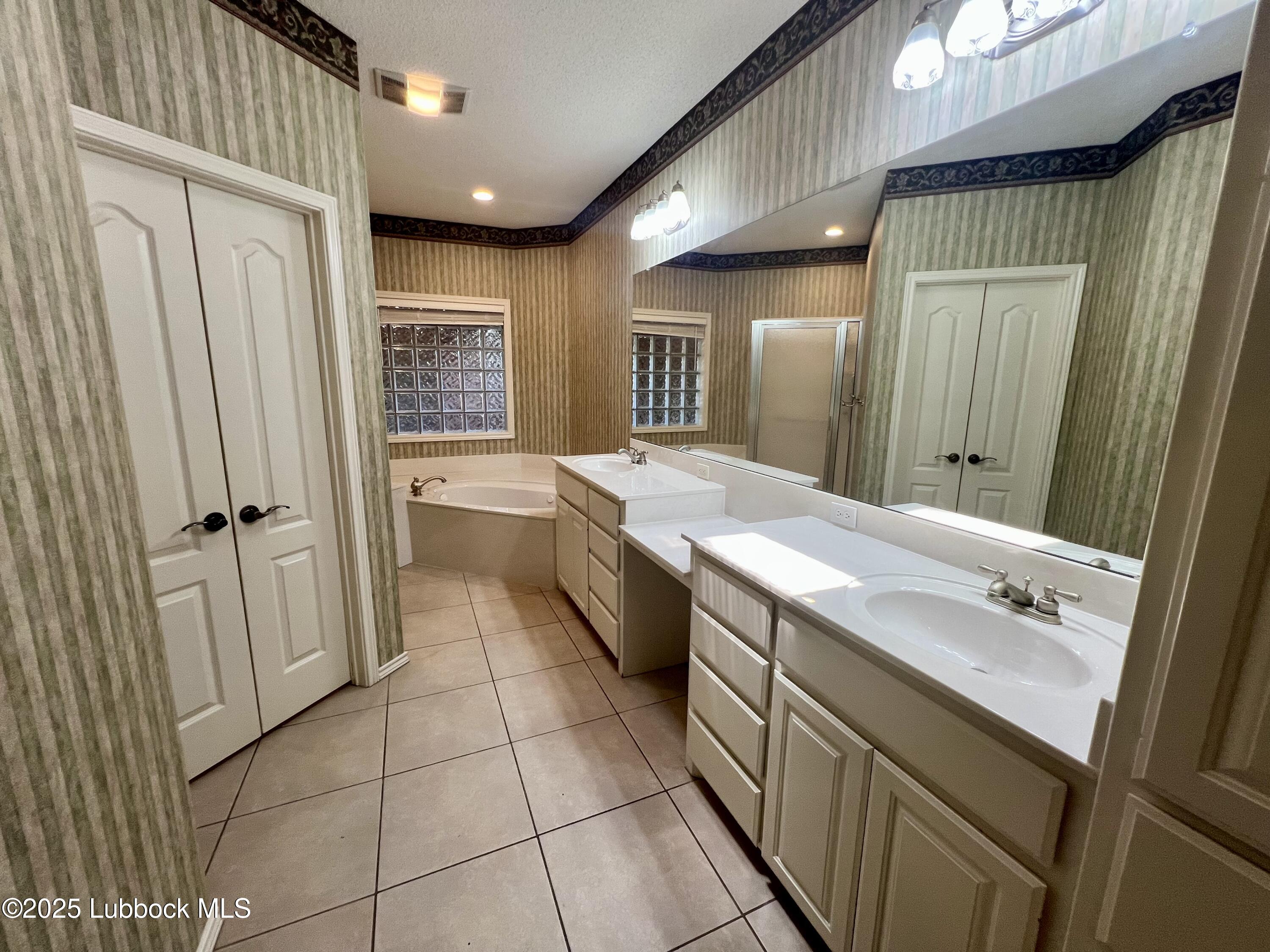 9802 Toledo Avenue Lubbock, TX 79424 - Photo 25 of 64 a bathroom with a sink a mirror and a bathtub