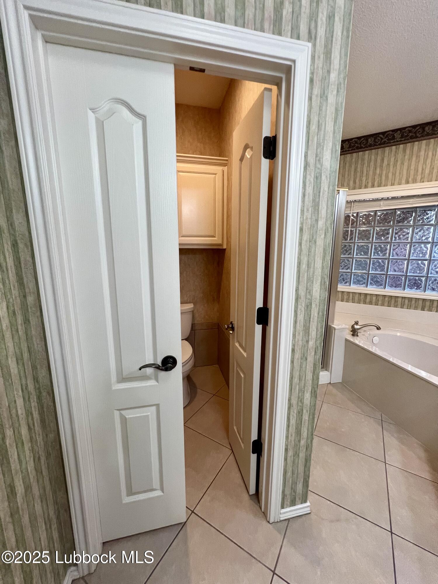 9802 Toledo Avenue Lubbock, TX 79424 - Photo 30 of 64 a view of a bathroom with a tub and door