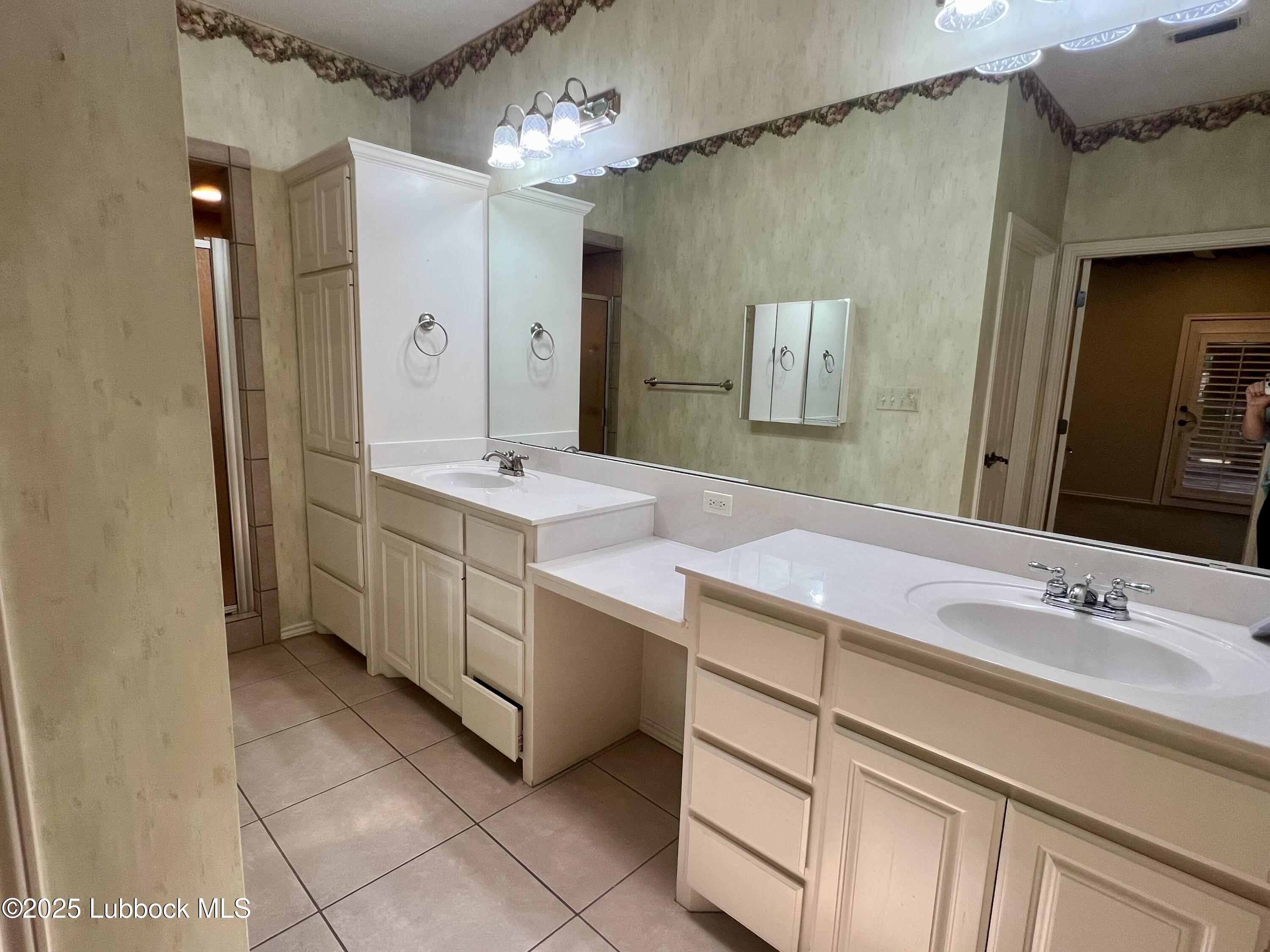 9802 Toledo Avenue Lubbock, TX 79424 - Photo 55 of 64 a bathroom with a sink double vanity and a mirror