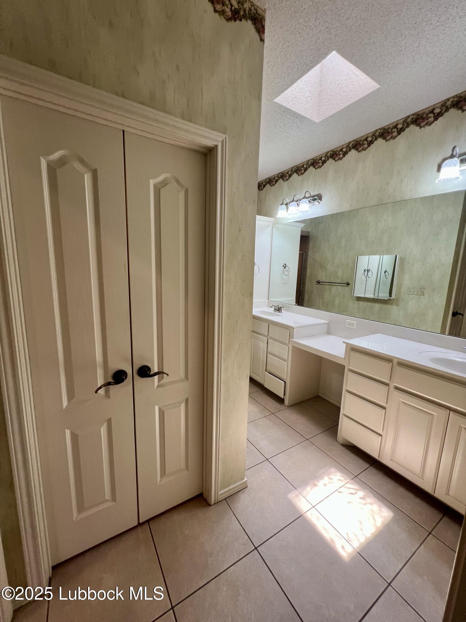9802 Toledo Avenue Lubbock, TX 79424 - Photo 57 of 64 a bathroom with a double vanity sink and mirror