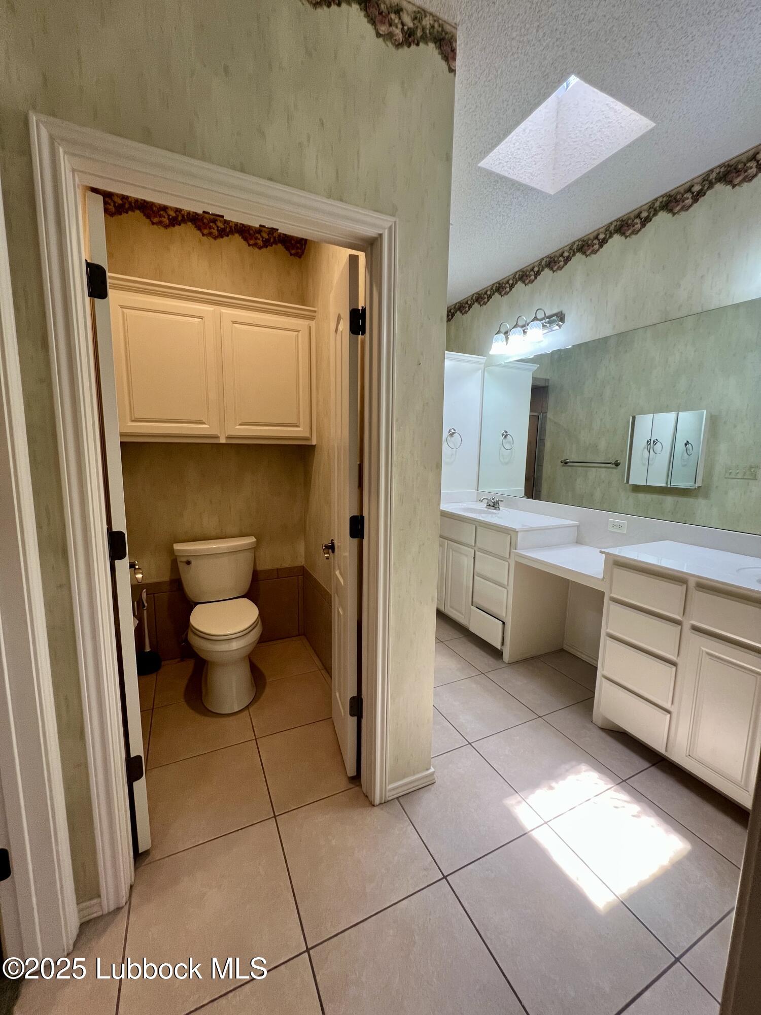 9802 Toledo Avenue Lubbock, TX 79424 - Photo 62 of 64 a bathroom with a toilet a sink and mirror