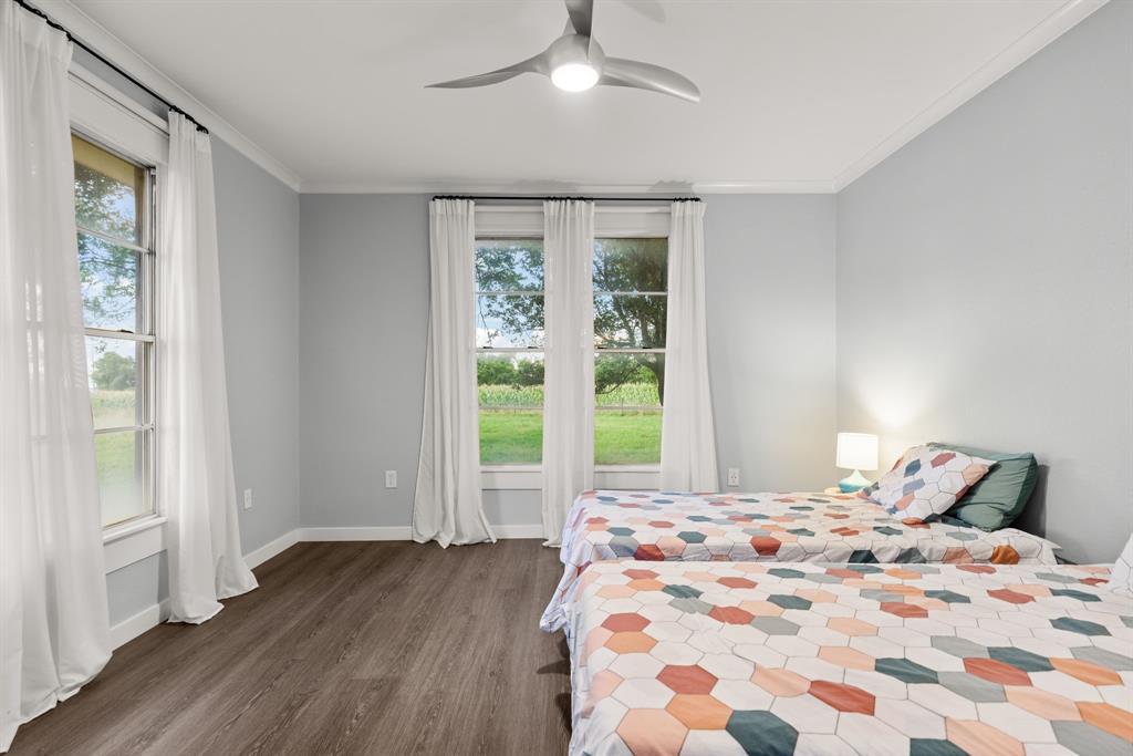 300 Grellhesl Road West, TX 76691 - Photo 22 of 35 a bedroom with a bed and a large window with wooden floor