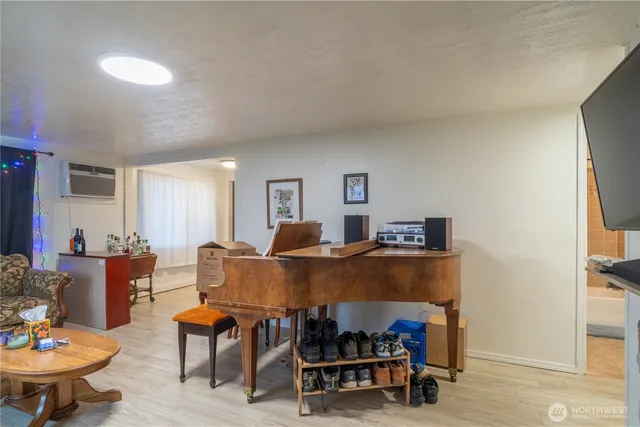 a living room with furniture and a dining table with wooden floor