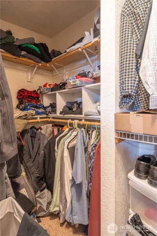 a view of walk in closet with clothes and shoes