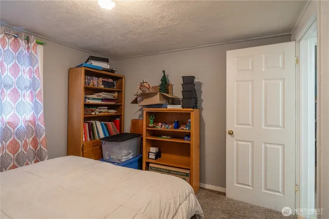 a bedroom with a bed and a book shelf