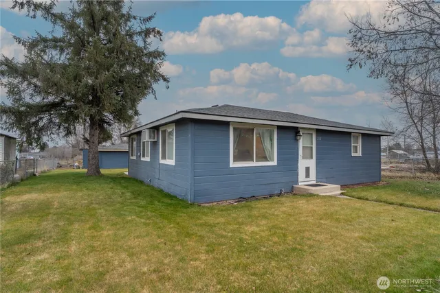 a brick house with a big yard large trees and brick walls