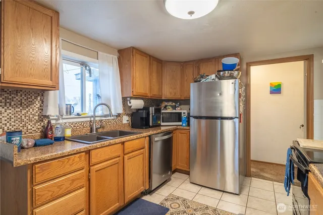 a kitchen with appliances a sink and a window